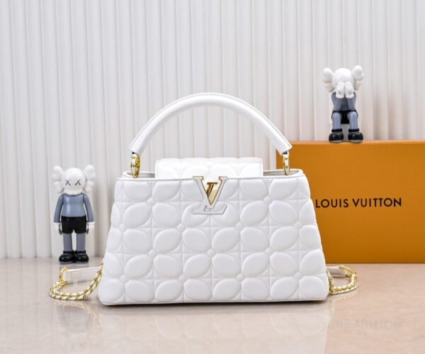 M23999 white. This Monogram embroidered floral design emerges in the elegant quilting, adding to the Louis Vuitton store's decoration style for the Capucines BB handbag. 33 x 19 x 9 cm