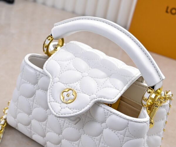 M23998 White. This Monogram embroidered floral design appears in the elegant quilting. Capucines mini handbag. Dimensions: 22 x 12 x 8 cm.