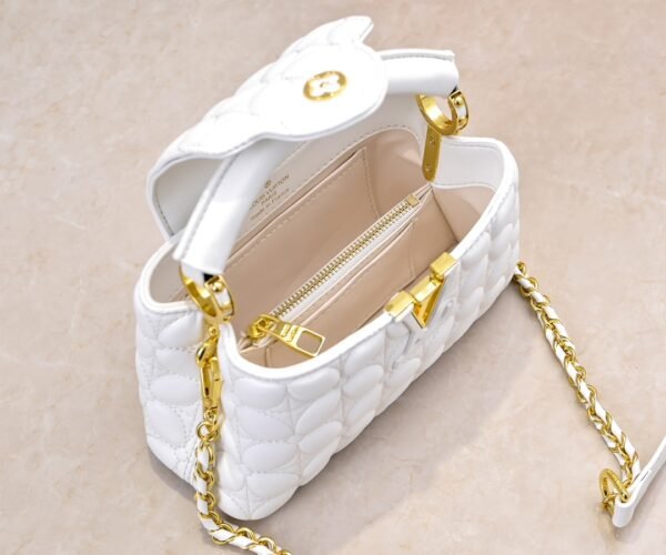 M23998 White. This Monogram embroidered floral design appears in the elegant quilting. Capucines mini handbag. Dimensions: 22 x 12 x 8 cm.