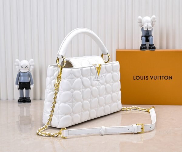 M23999 white. This Monogram embroidered floral design emerges in the elegant quilting, adding to the Louis Vuitton store's decoration style for the Capucines BB handbag. 33 x 19 x 9 cm