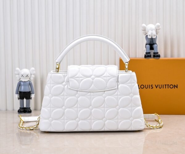 M23999 white. This Monogram embroidered floral design emerges in the elegant quilting, adding to the Louis Vuitton store's decoration style for the Capucines BB handbag. 33 x 19 x 9 cm