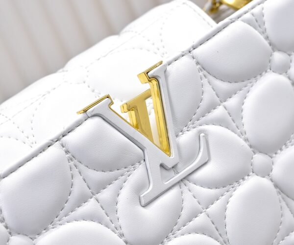 M23999 white. This Monogram embroidered floral design emerges in the elegant quilting, adding to the Louis Vuitton store's decoration style for the Capucines BB handbag. 33 x 19 x 9 cm