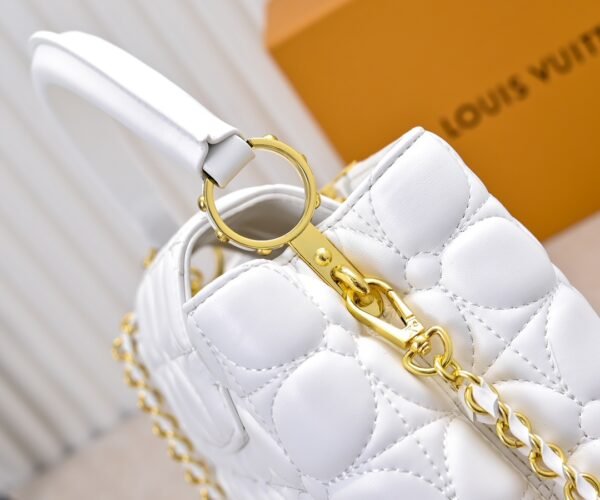 M23999 white. This Monogram embroidered floral design emerges in the elegant quilting, adding to the Louis Vuitton store's decoration style for the Capucines BB handbag. 33 x 19 x 9 cm