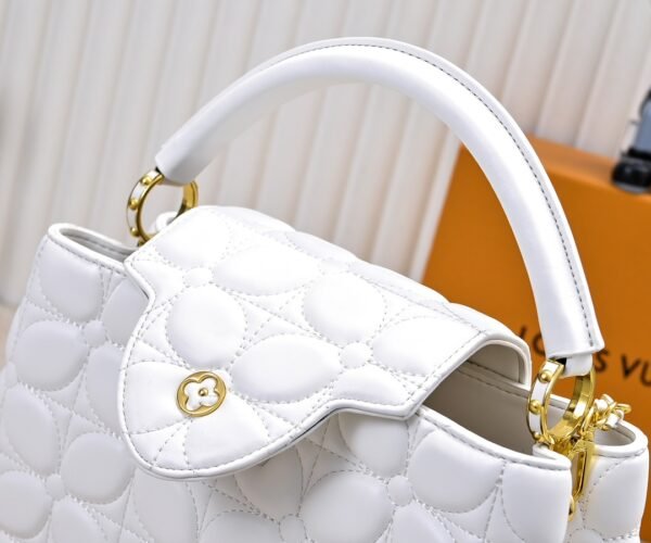 M23999 white. This Monogram embroidered floral design emerges in the elegant quilting, adding to the Louis Vuitton store's decoration style for the Capucines BB handbag. 33 x 19 x 9 cm