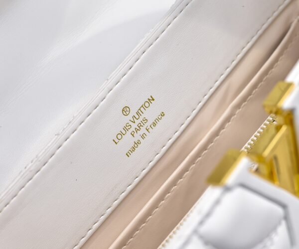 M23999 white. This Monogram embroidered floral design emerges in the elegant quilting, adding to the Louis Vuitton store's decoration style for the Capucines BB handbag. 33 x 19 x 9 cm